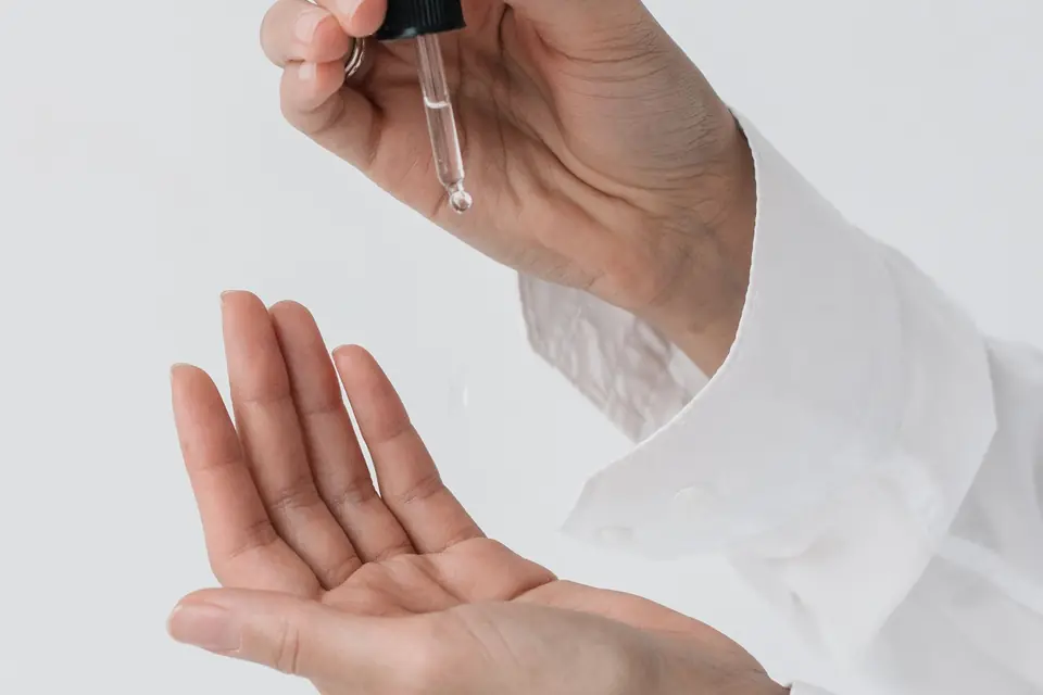Een pipet met serum boven een open hand